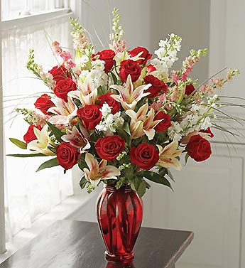 roses, stargazer lilies, larkspur, red glass vase