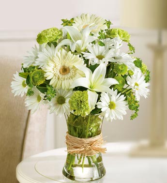green and white flowers in clear vase